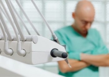 Foto De Paciente Hombre De Complexión Delgada Usando Bata Hospitalaria, Esperando En Sala Médica. - Regios Al Cuadrado