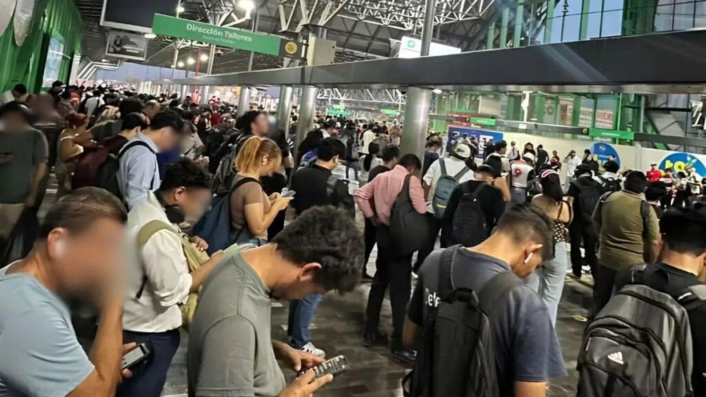 Linea-1-metro-samuel-garcia - Regios Al Cuadrado Crowded Indoor Concourse with Many People Standing in Line, Many Looking at Their Phones, Signs Overhead Indicating Directions in Spanish. - Regios Al Cuadrado
